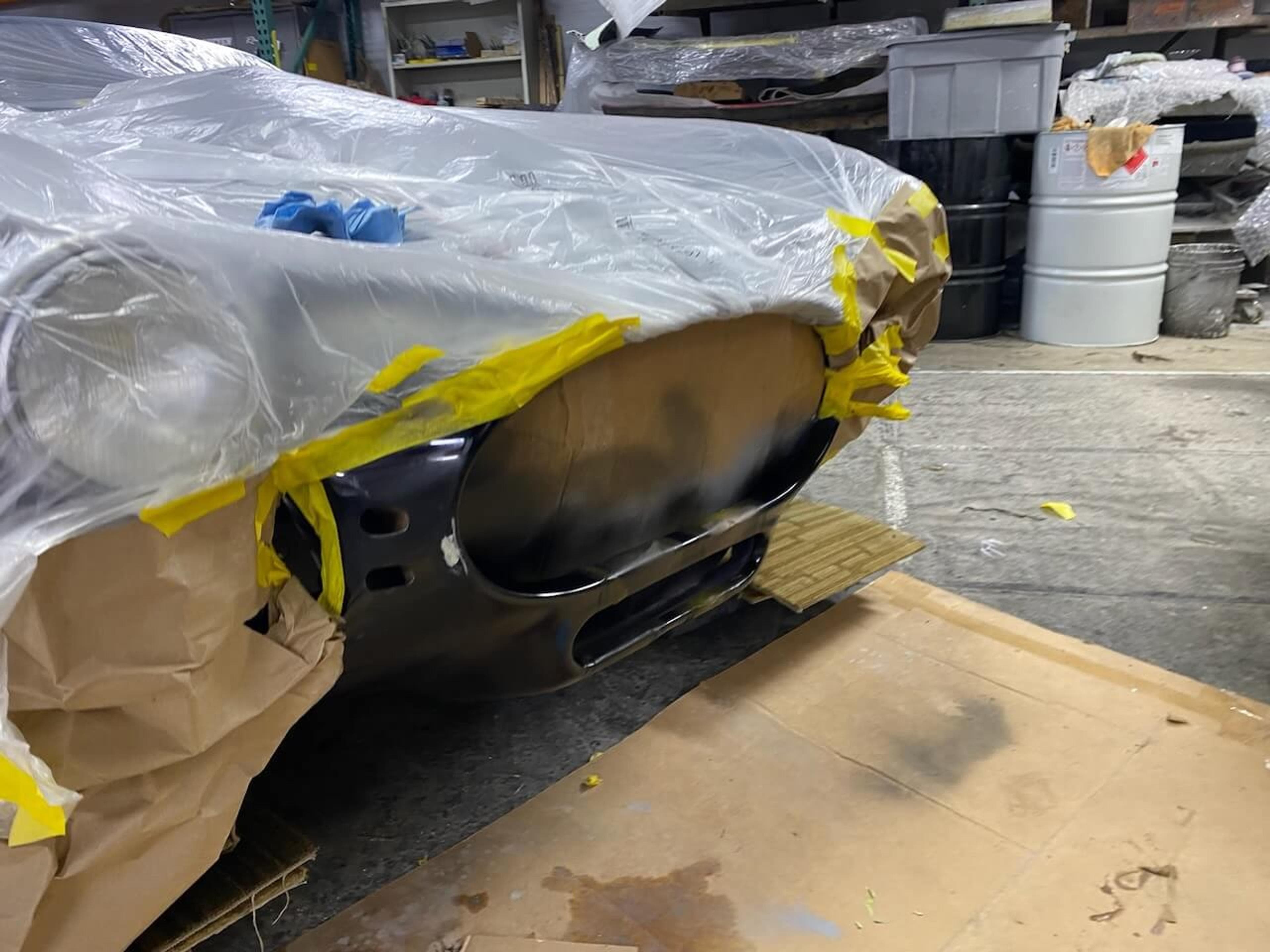 Front body repair masked for refinishing Shelby Cobra-style roadster with the repaired front fiberglass body section masked and prepared for refinishing.