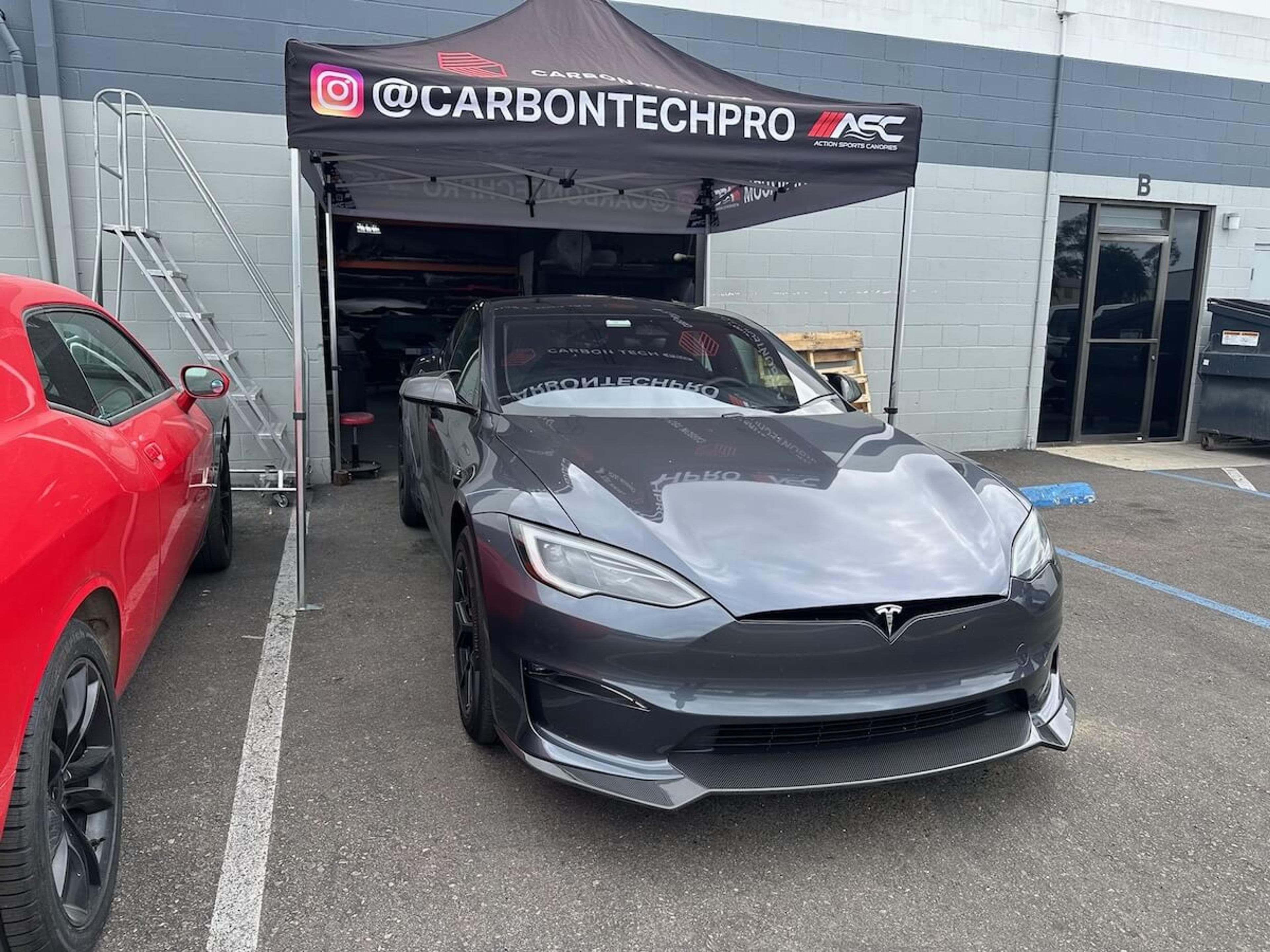 Finished Tesla Model Y front lip installation Gray Tesla Model Y with installed carbon fiber front lip outside Carbon Tech Pro