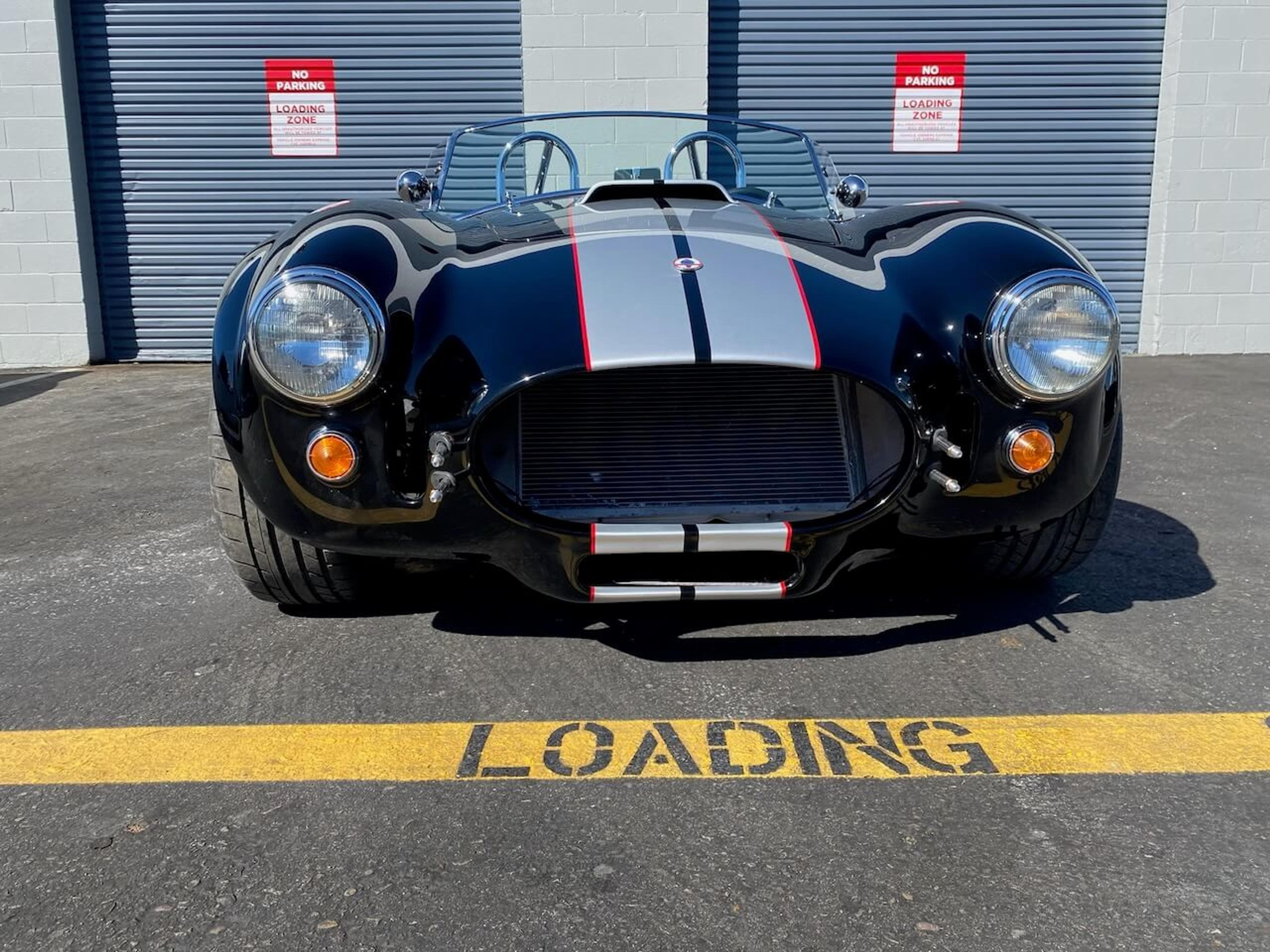 Finished Shelby Cobra-style roadster Straight-on view of the completed black Shelby Cobra 427-style roadster after fiberglass repair