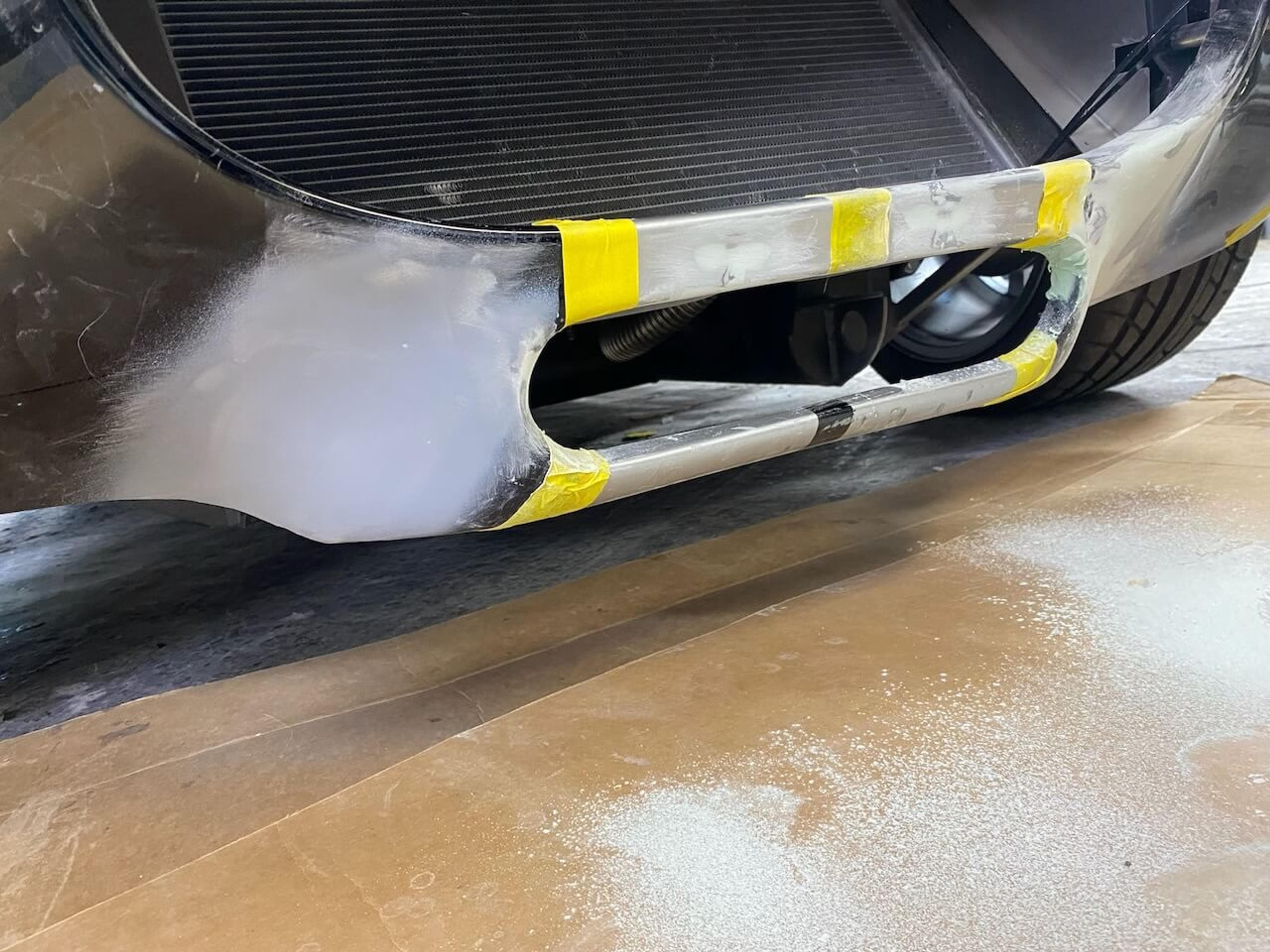 Fiberglass repair and reshaping in progress Front lower body of a Shelby Cobra-style roadster sanded and reshaped during fiberglass repair
