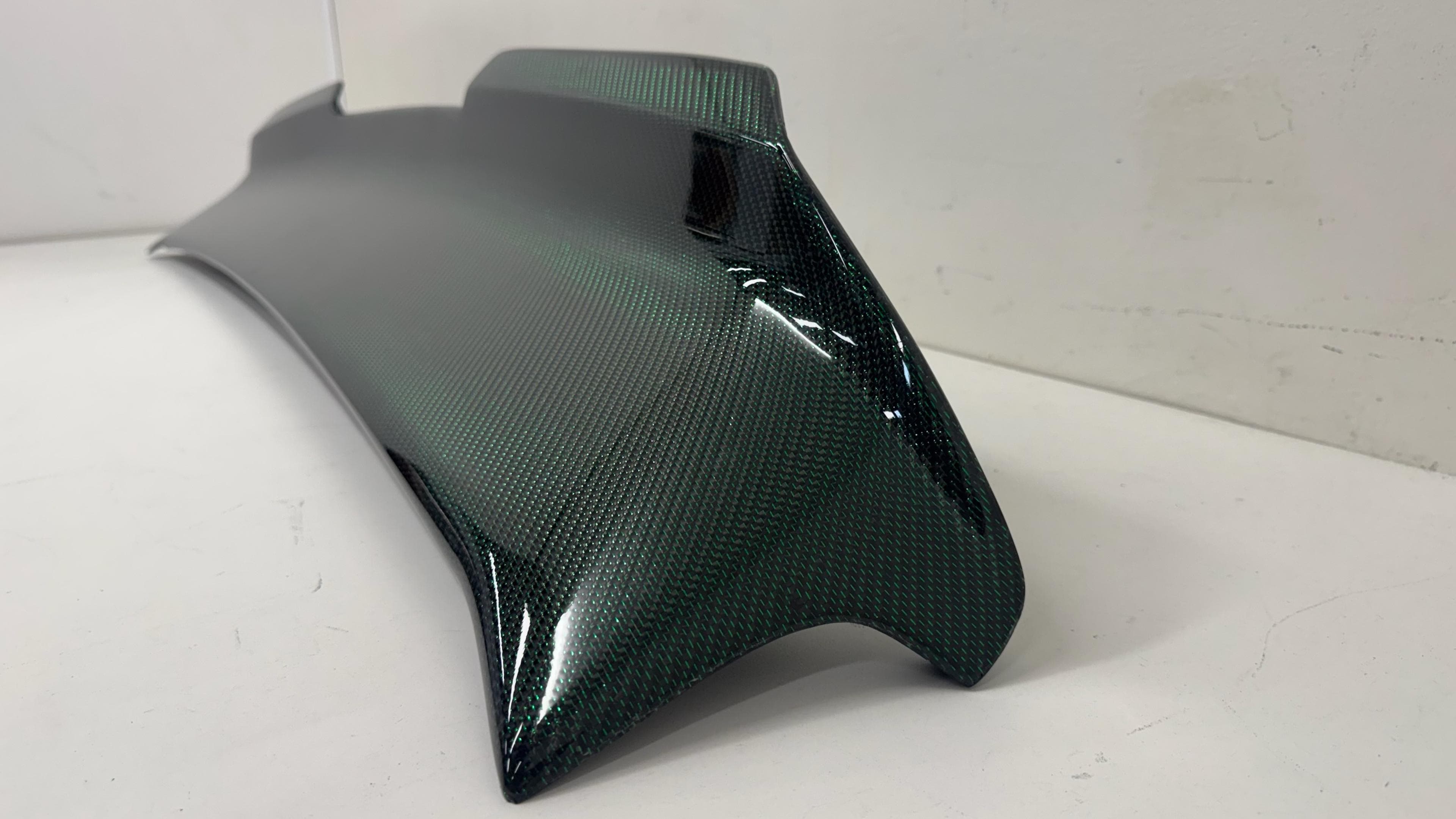 Green reflective carbon fiber spoiler weave finish Close-up of green twill reflective carbon fiber spoiler weave finish.
