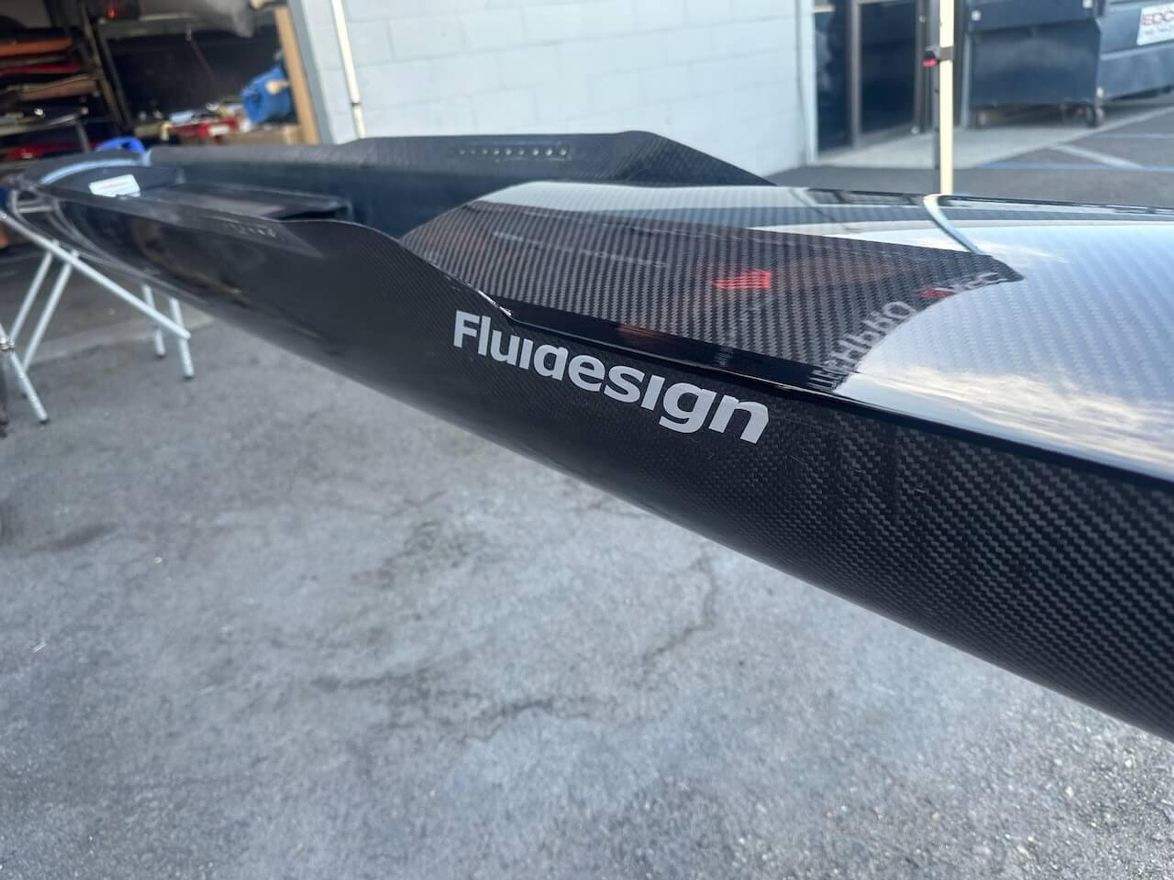 Finished Fluidesign shell detail Close-up of Fluidesign logo and finished carbon fiber surface after repair