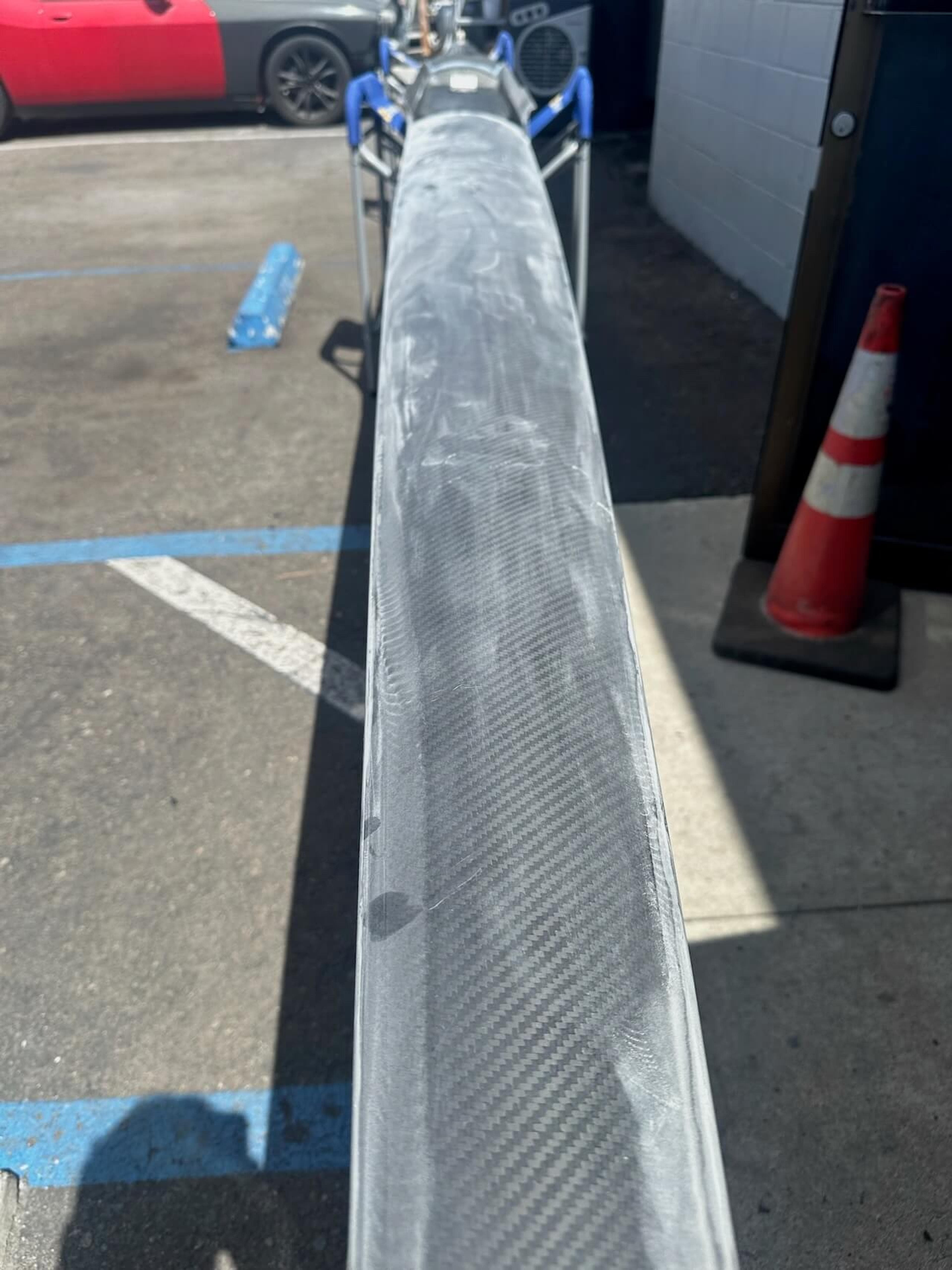Damaged area prepared for repair Sanded and damaged section of a Fluidesign carbon fiber rowing shell before repair