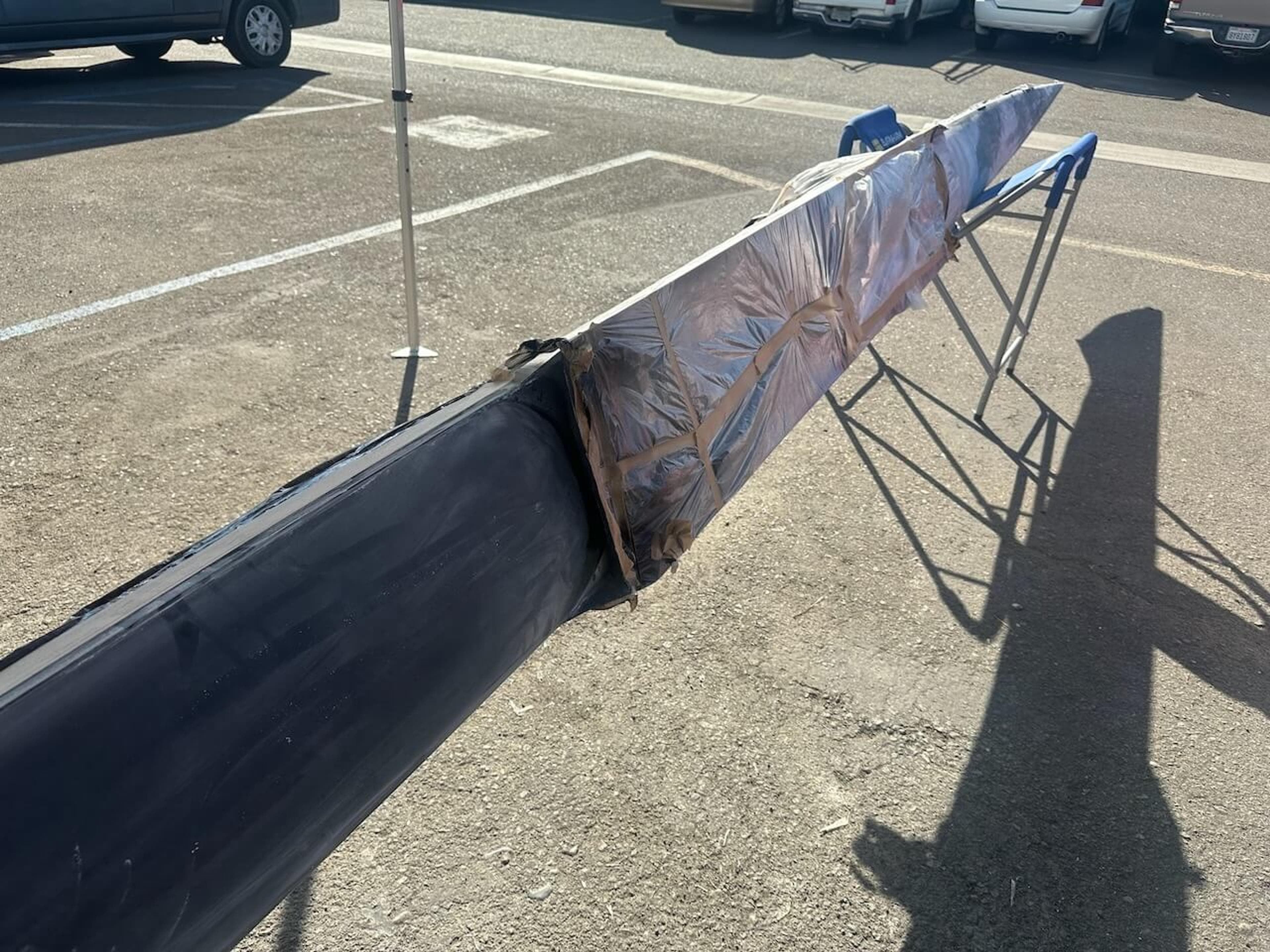 Repair area masked and protected Fluidesign carbon fiber rowing shell with the repair area masked and wrapped during the repair process