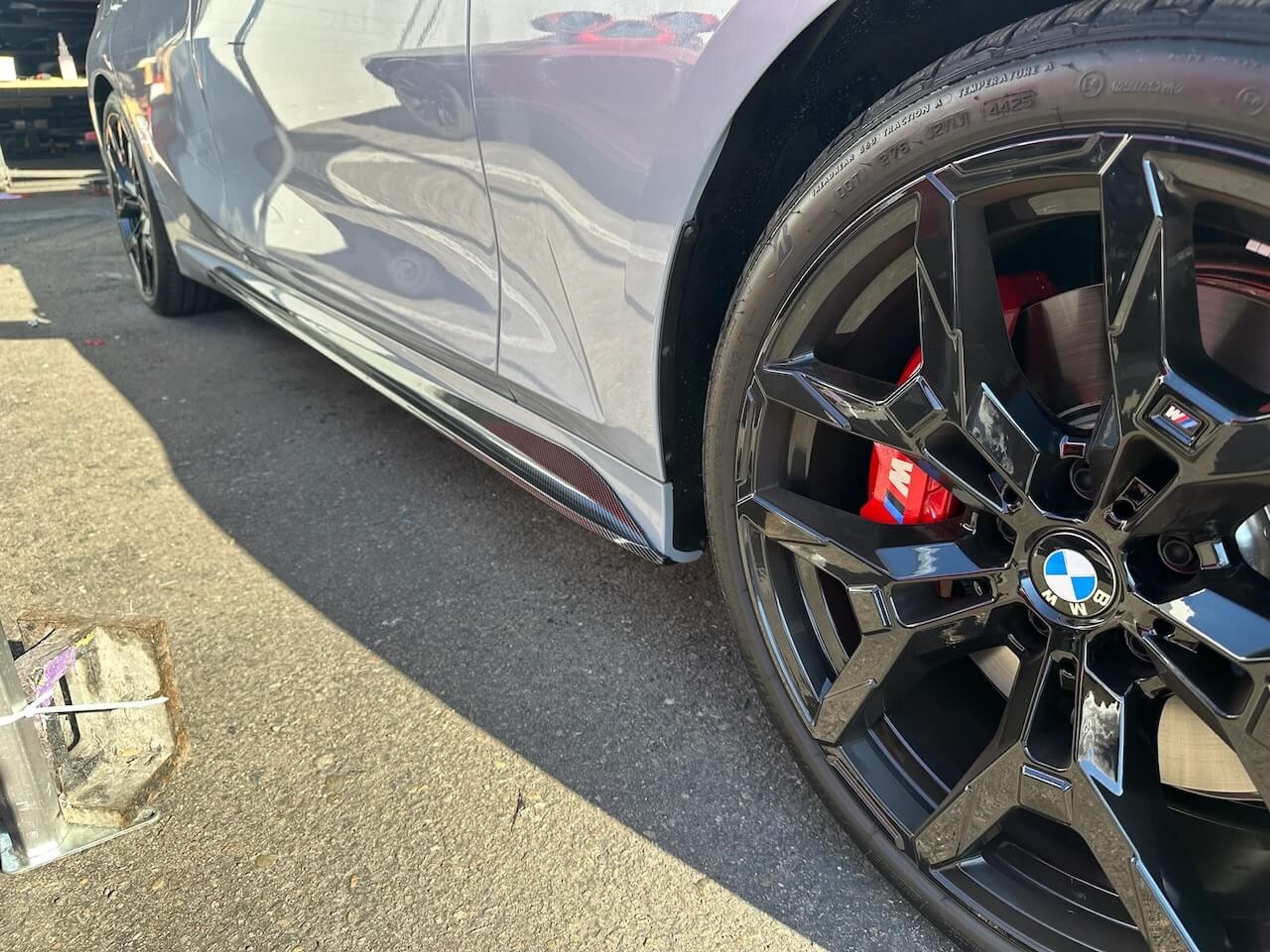Rear diffuser installation in progress Rear view of a BMW M340i with the lower diffuser removed and installation components laid out below