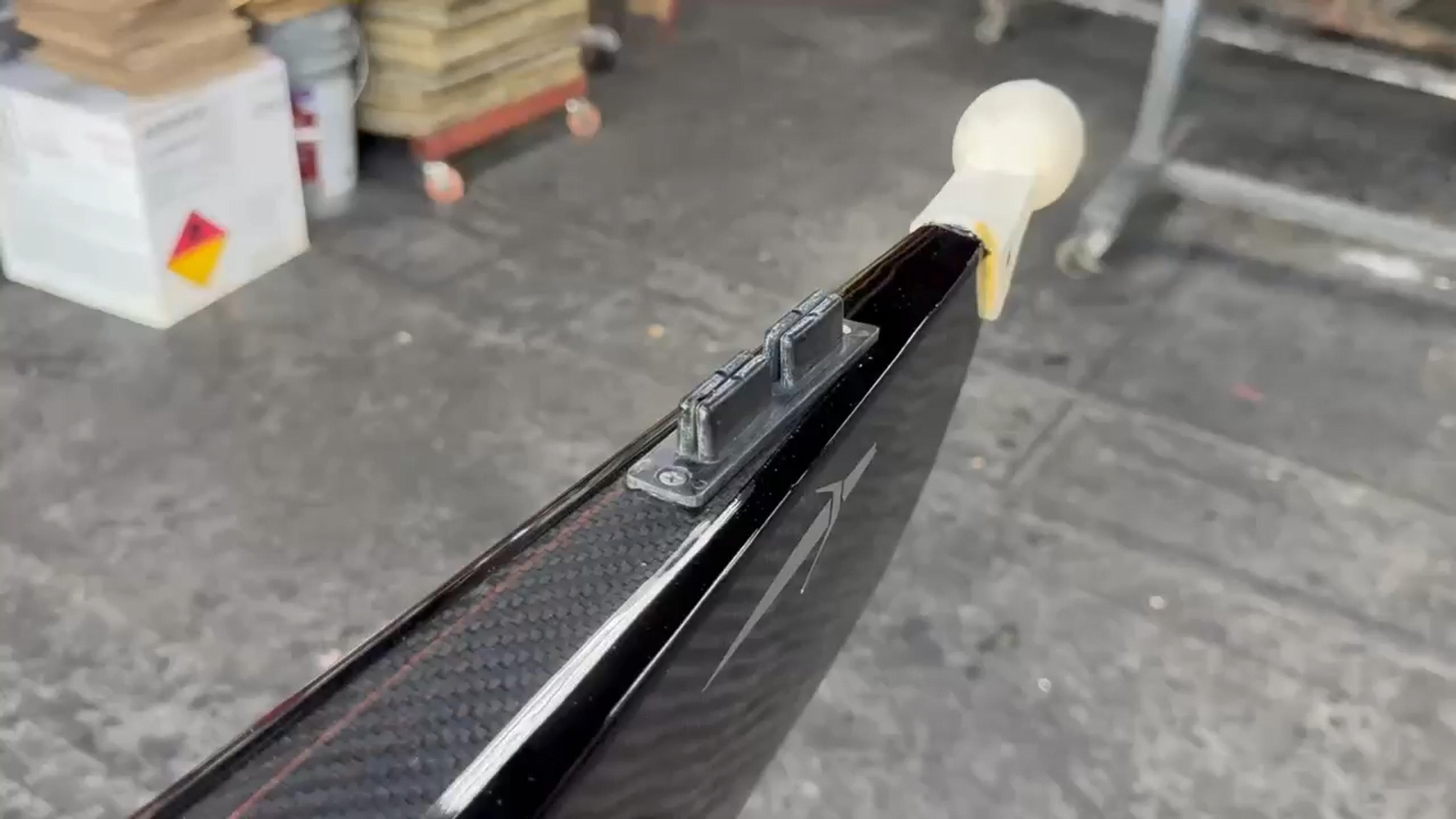 Full-length view of the repaired Fluidesign rowing shell End-to-end video showing the restored carbon fiber finish of a Fluidesign high-performance rowing shell after repair.