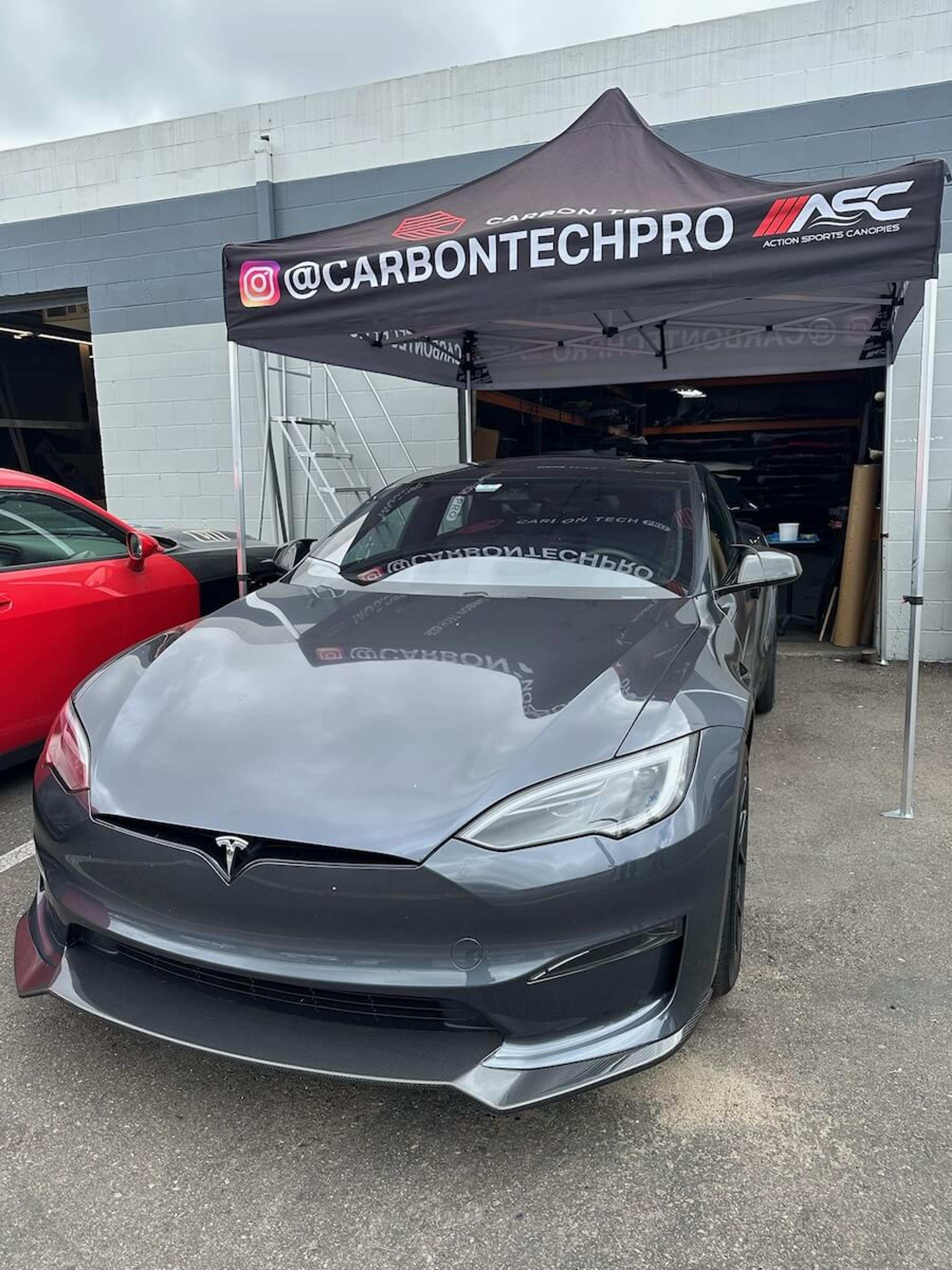 Completed carbon fiber front lip fitment Front three-quarter view of Tesla Model Y with carbon fiber front lip installed