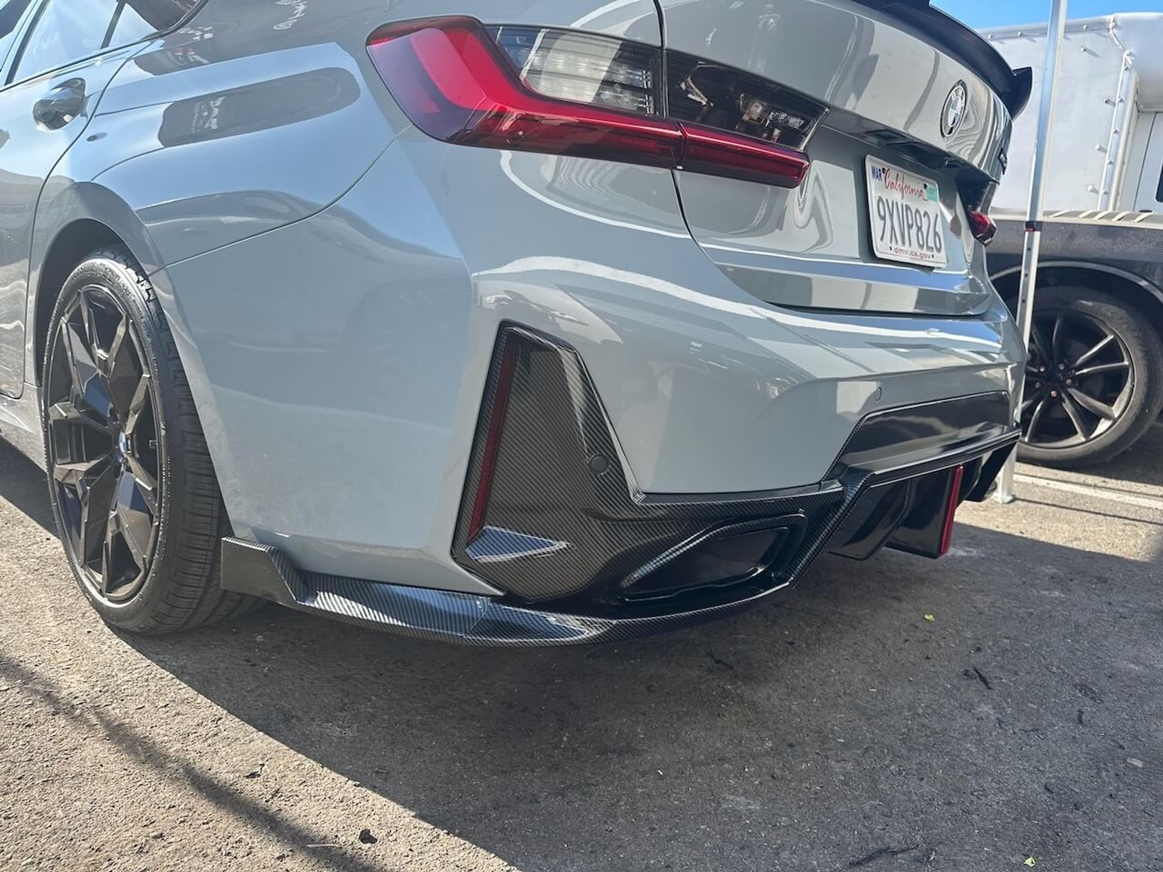 Carbon fiber rear diffuser installation Rear three-quarter view of a gray BMW M340i with an installed carbon fiber rear diffuser
