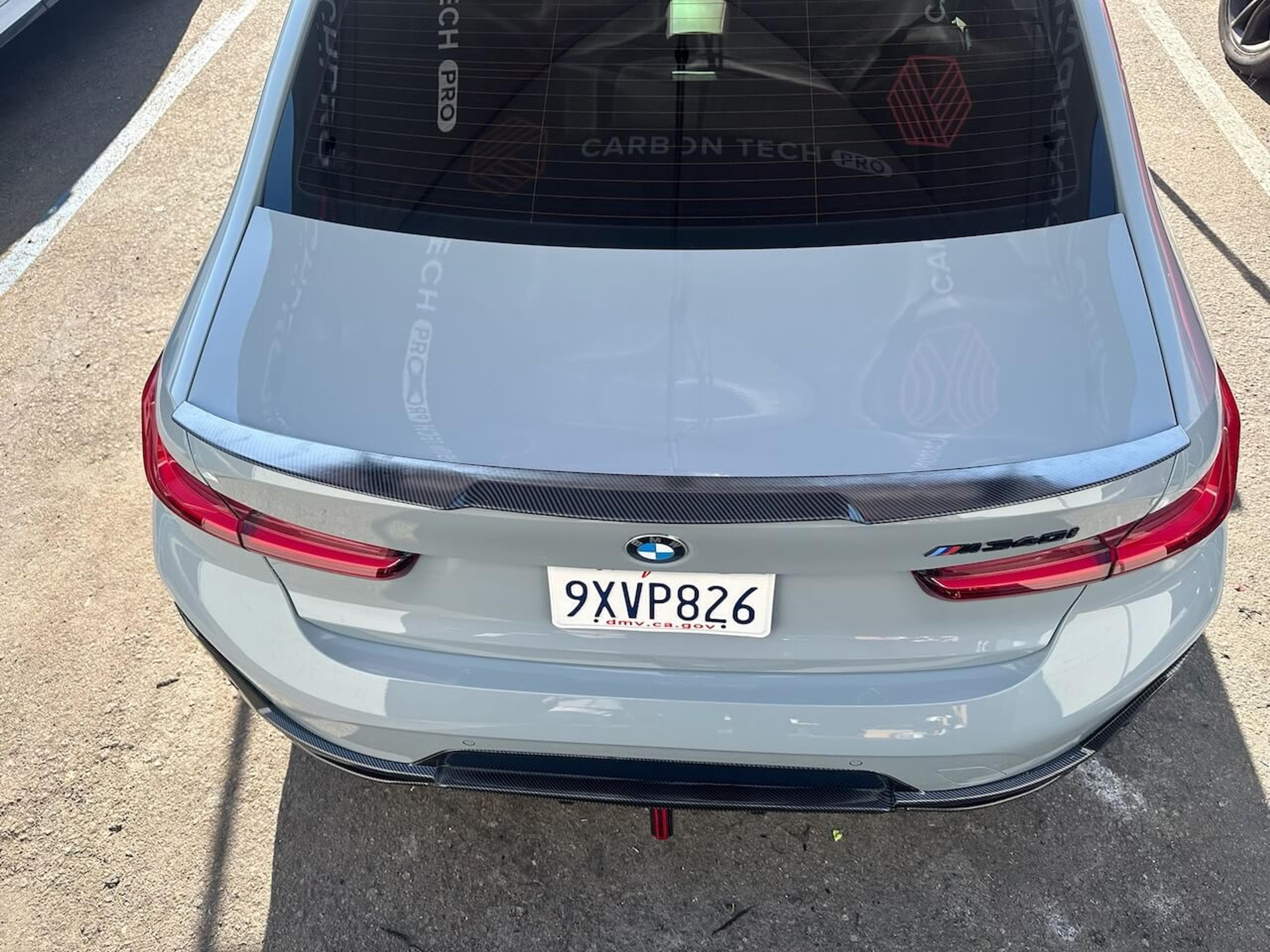 Carbon fiber trunk spoiler installation Overhead rear view of a BMW M340i showing the installed carbon fiber trunk spoiler